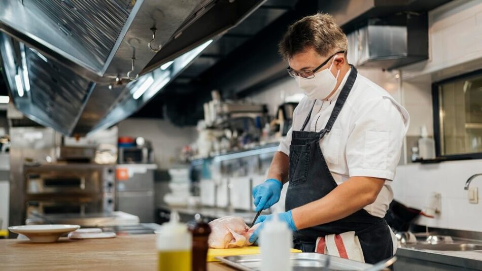 Cuisinier masqué préparant un plat.