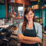 Barista souriante devant machine à café dans café